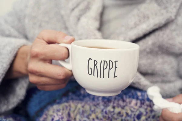 Hombre enfermo y taza con grippe palabra, gripe en francés —  Fotos de Stock