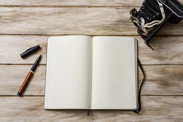 Notebook em branco, caneta e câmera antiga — Fotografia de Stock