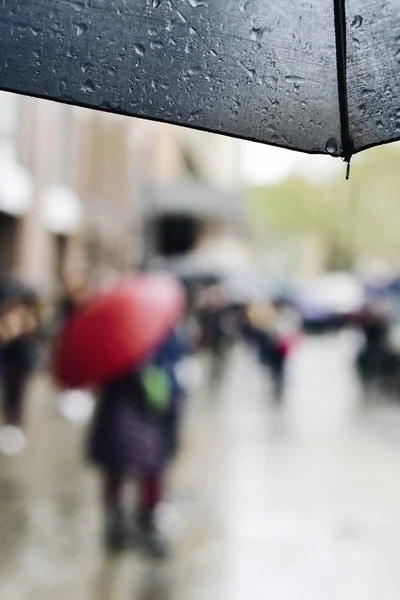 Umbrella and people walking under the rain — Stock Photo, Image
