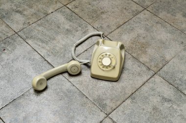 retro rotary telephone on a tiled floor clipart