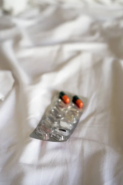 Pills in a blister pack on a bed — Stock Photo, Image