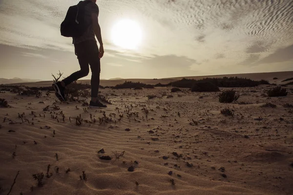 Man met een rugzak lopen in de woestijn — Stockfoto