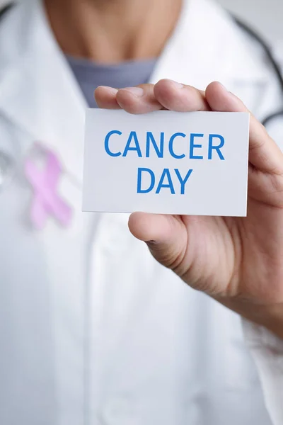 Médico e sinalização com o dia do câncer de texto — Fotografia de Stock