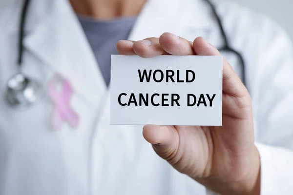Doctor and signboard with text world cancer day — Stock Photo, Image