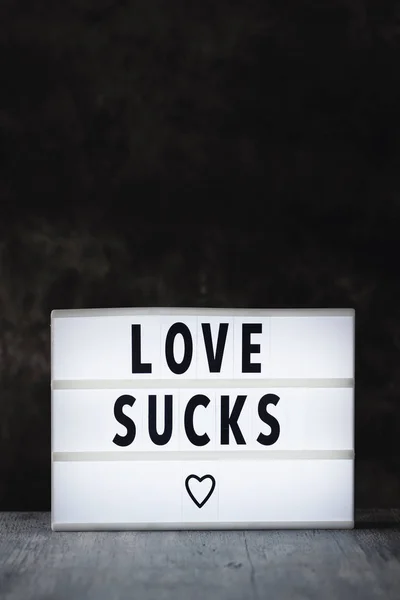Text love sucks in a lightbox — Stock Photo, Image