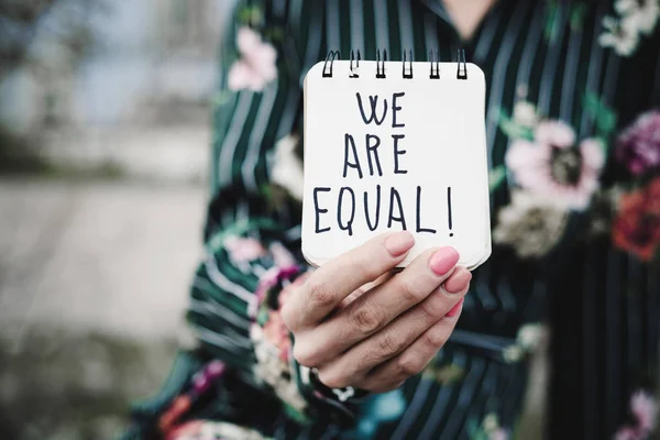 Vrouw toont Kladblok met de tekst zijn wij gelijk — Stockfoto