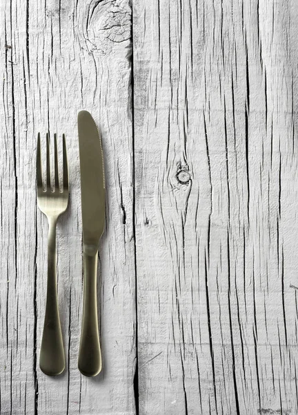 Вилка и нож на белом деревенском деревянном столе — стоковое фото