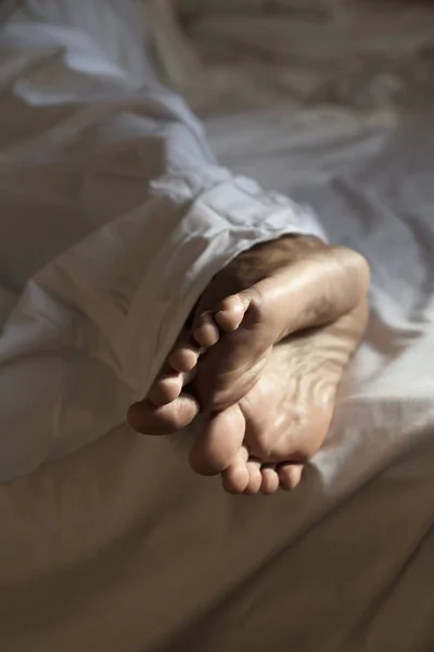 Young man lying down on bed — Stock Photo, Image