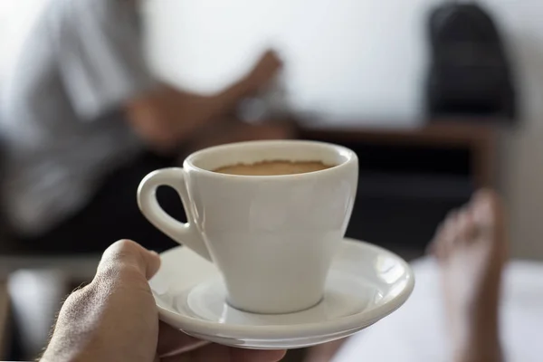 Молодой человек, пьющий кофе в постели — стоковое фото