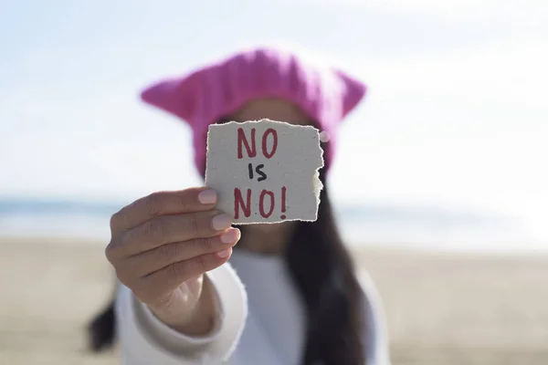 Kvinna med en rosa hatt och texten ingen är ingen — Stockfoto