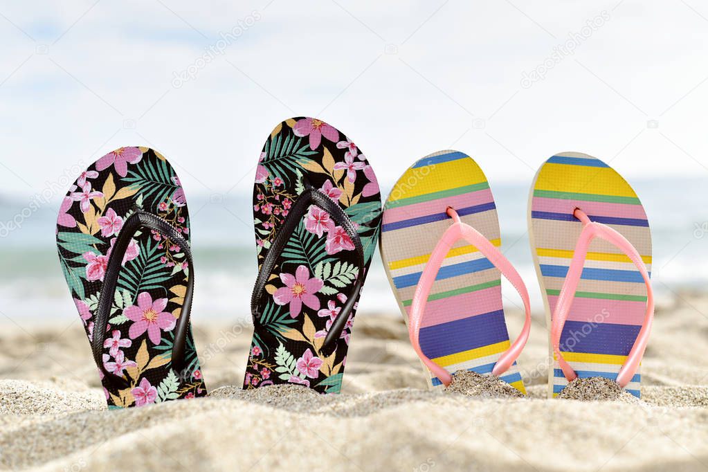 two pair of flip-flops on the beach