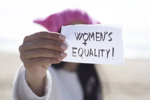 Mulher com um chapéu rosa e o texto mulheres igualdade — Fotografia de Stock