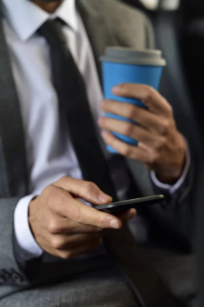 Hombre de negocios usando su teléfono inteligente en un coche — Foto de Stock