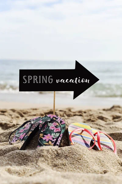 Slippers op het strand en de tekst voorjaar vakantie — Stockfoto