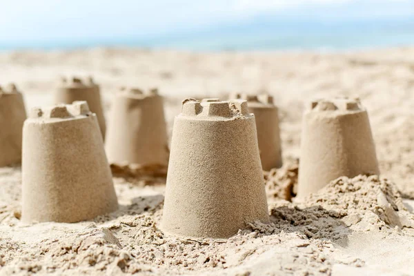 Castelos de areia na areia de uma praia — Fotografia de Stock