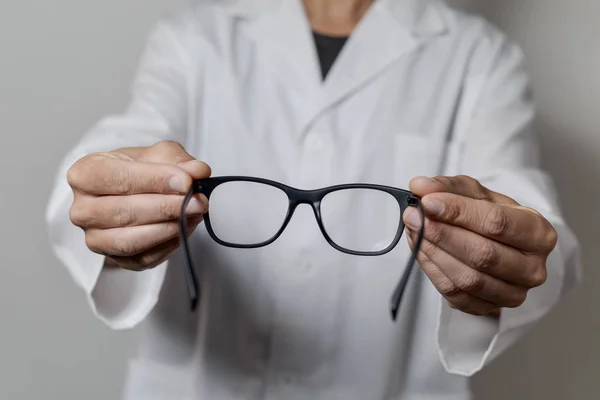 Homem óptico trazendo um par de óculos — Fotografia de Stock