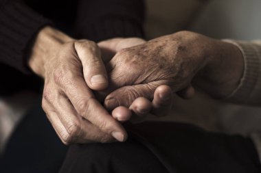 genç adam yaşlı bir kadın elini tutarak