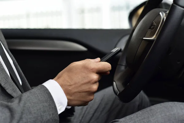 Homme d'affaires utilisant un smartphone dans une voiture — Photo