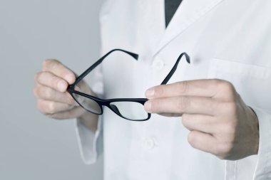 optician man checking a pair of eyeglasses clipart