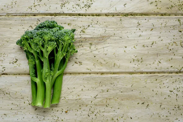Stems of broccolini on a wooden surface — Stock Photo, Image