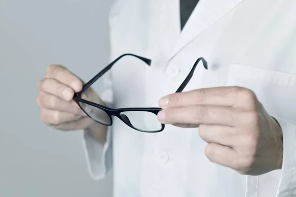 Hombre óptico revisando un par de anteojos — Foto de Stock