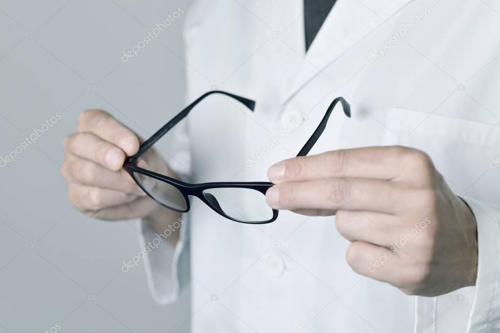optician man checking a pair of eyeglasses