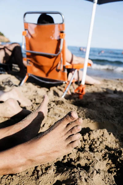 Oigenkännlig människor avkopplande på stranden — Stockfoto