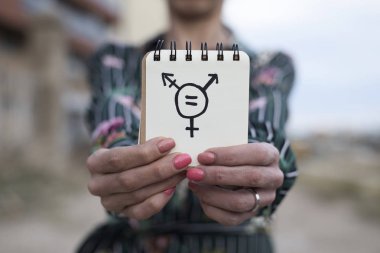 woman shows notepad with a transgender symbol clipart