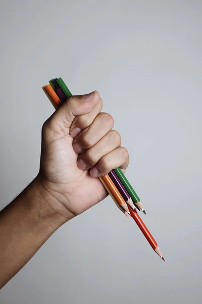 Young man wielding some sharpened pencil crayons — Stock Photo, Image