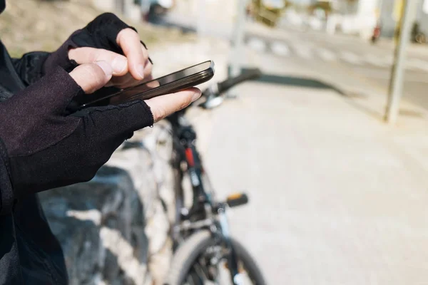 Jovem ciclista homem usando um smartphone — Fotografia de Stock