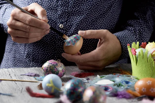 Hombre joven decorando huevos caseros de Pascua — Foto de Stock