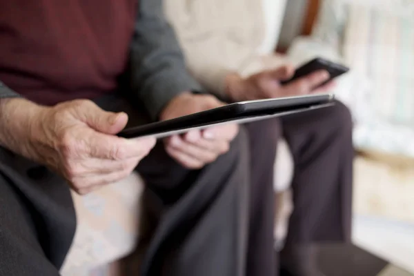 Anciana y anciano usando dispositivos electrónicos — Foto de Stock