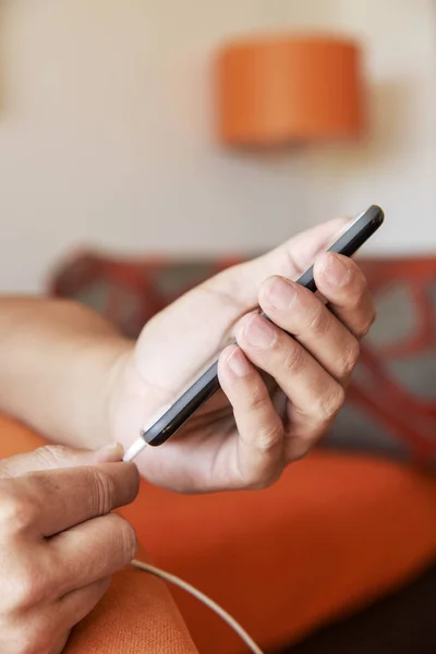 Man att ansluta en kabel till hans smpartphone — Stockfoto