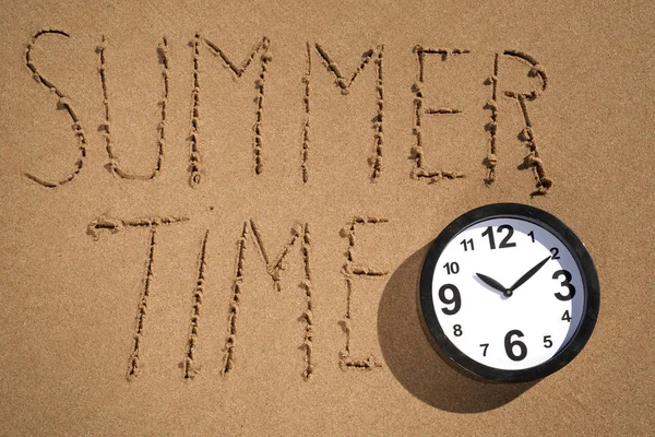 Relógio e texto hora de verão na praia — Fotografia de Stock