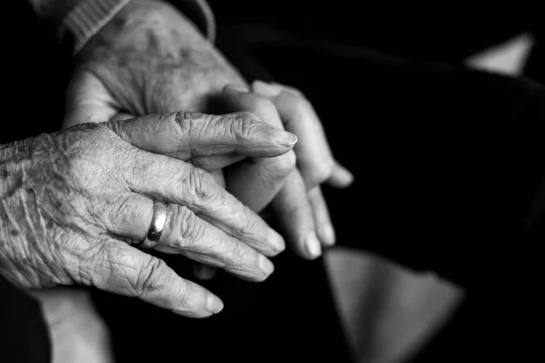 Oude vrouw met de hand van jonge man — Stockfoto