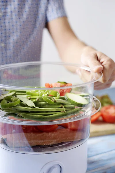 Man koken met een stoomkoker — Stockfoto