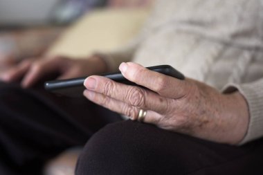 Akıllı telefon kullanan yaşlı kadın.