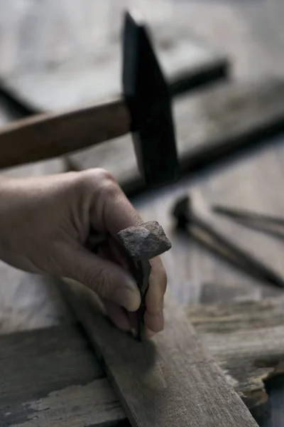 Mann schlägt Nagel auf Holzkreuz — Stockfoto