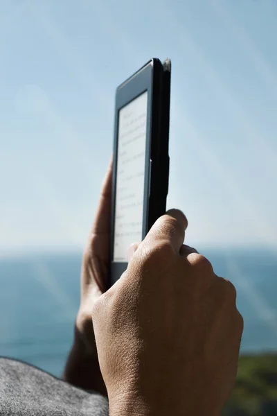 Homme lisant dans une tablette ou un lecteur électronique — Photo