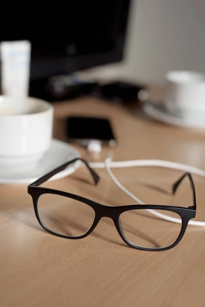Eyeglasses, cup of coffee and smartphone — Stock Photo, Image
