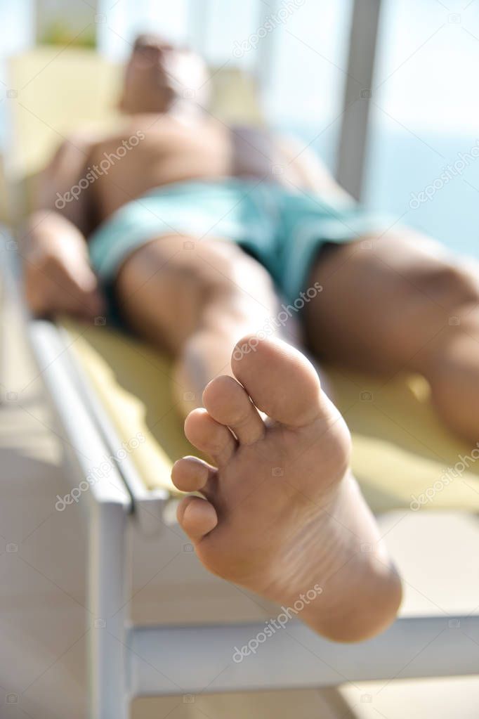 young man sun tanning in a sunlounger