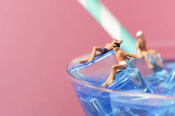 Miniature men in swimsuit on a cocktai — Stock Photo, Image