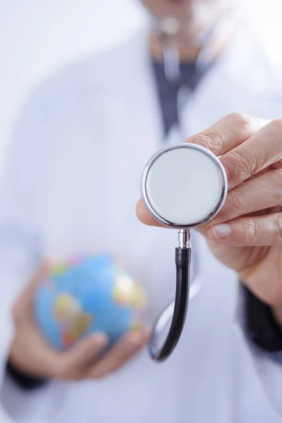 Docteur homme avec un stéthoscope et un monde globuleux — Photo