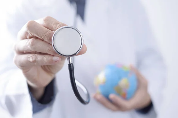 Arts man met een stethoscoop en een wereld-glob — Stockfoto
