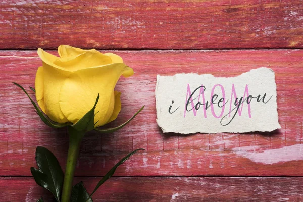 Желтая роза и текст I love you mom in a note — стоковое фото