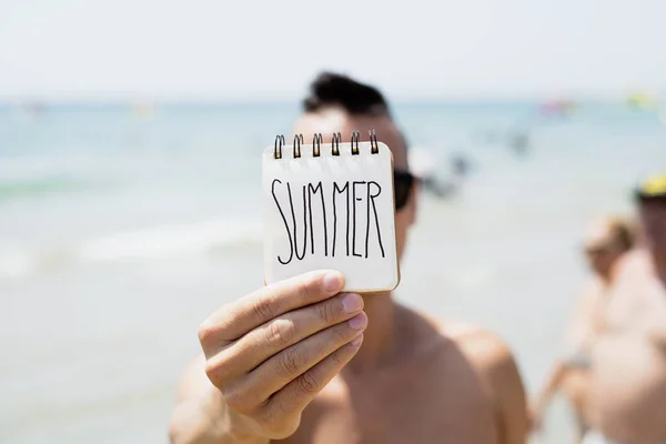 Young man with a note with the word summe — Stock Photo, Image