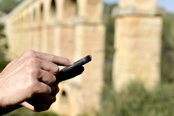 Mann mit Telefon am römischen Aquädukt von Tarragona — Stockfoto