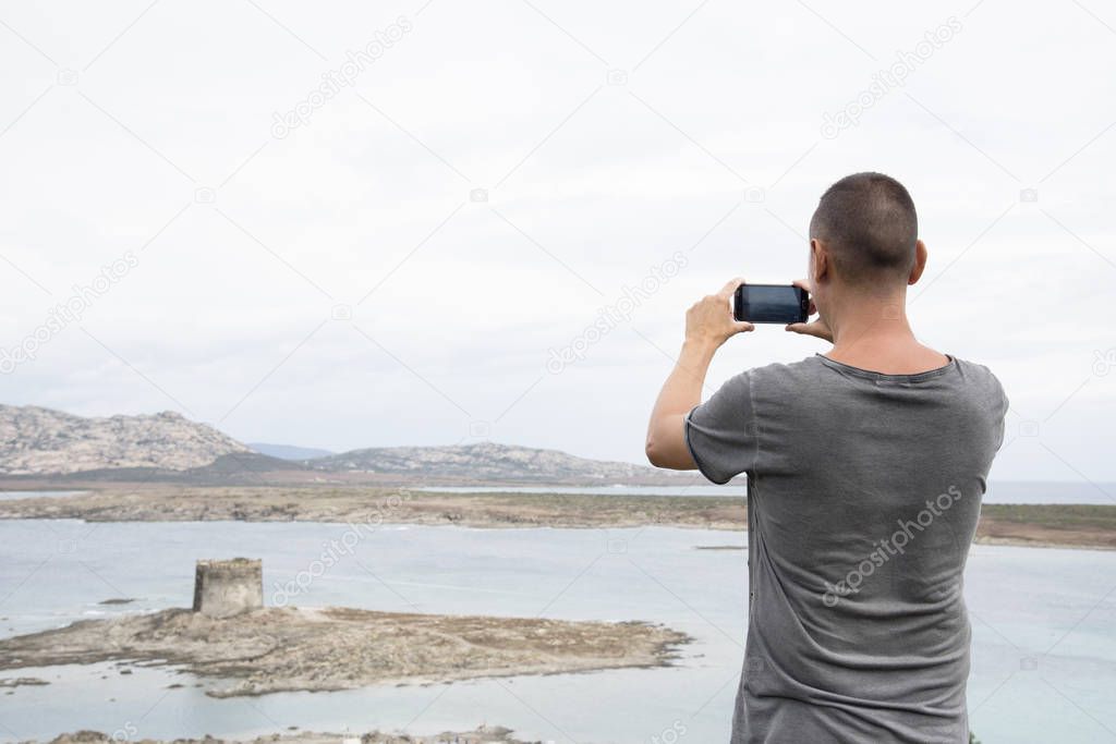 young man taking a picture in Sardinia, Italy