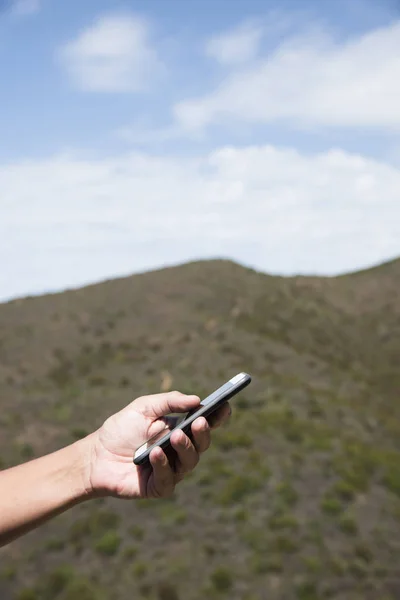 Homme utilisant un smartphone dans les montagnes — Photo