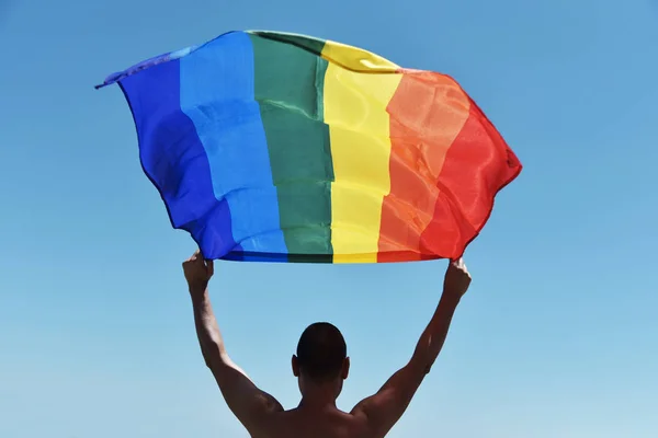 Homem com uma bandeira do arco-íris sobre a cabeça — Fotografia de Stock